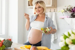 a pregnant woman eating a salad